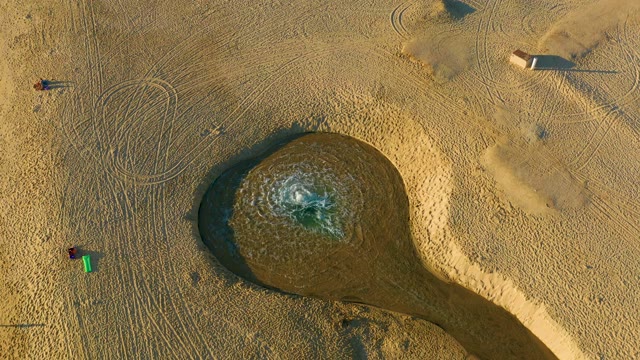 Overhead View of People Moving Near Sandy Water Feature