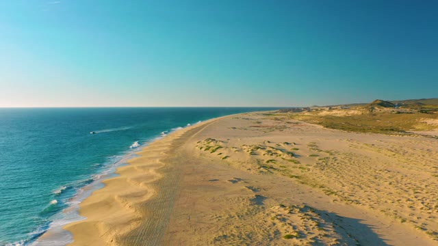 Distant Boat Navigating Sandy Coastline