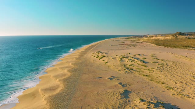 Sandy Shore and Ocean with Boat Moving Along Coast