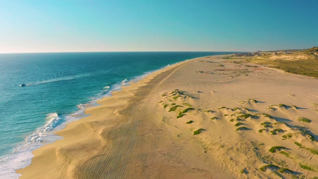 Boat Moving Along Sandy Coast with Dunes