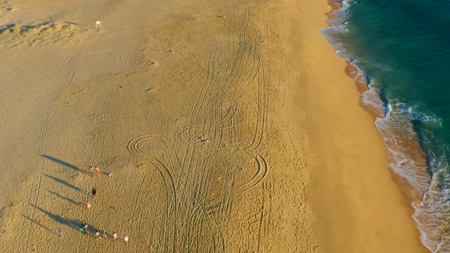 People Departing a Sandy Beach