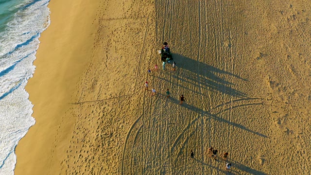 People and Vehicle Moving on Sandy Beach