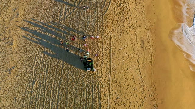 People on Sandy Beach with Ocean Waves