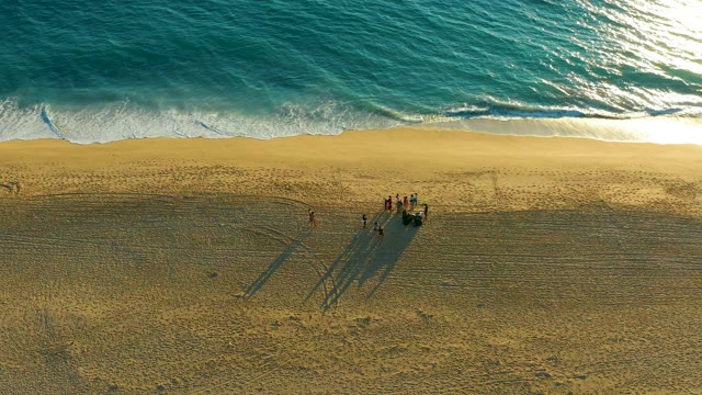 People on Sandy Beach with Ocean Waves Rolling In