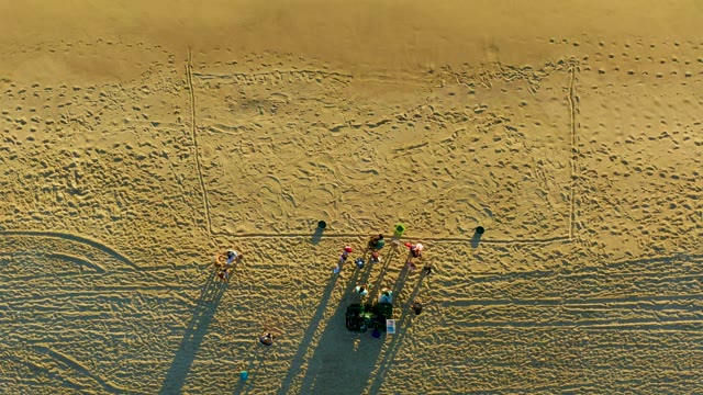 Group of People Moving on Sandy Beach