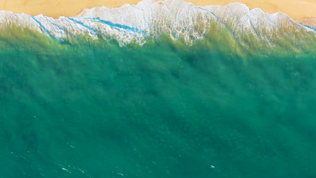 Waves Breaking on Sandy Shore From Above