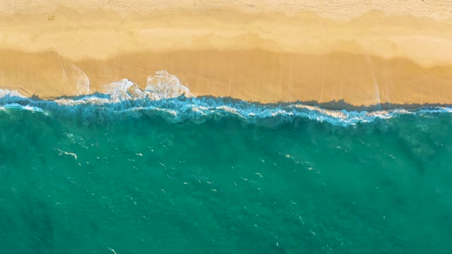 Sandy Beach and Rolling Ocean Waves