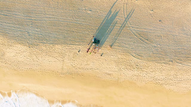 Beachgoers Standing As Ocean Waves Recede