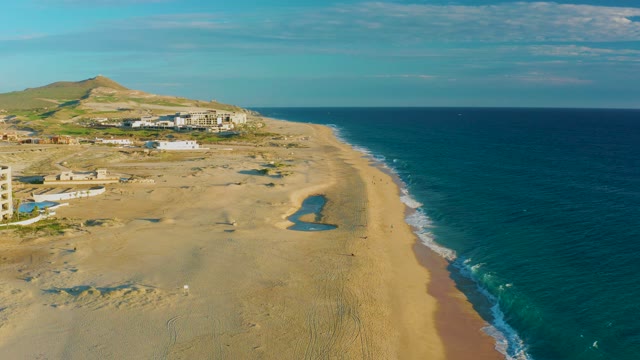 Sandy Beach with Moving Ocean Waves and Coastal Buildings