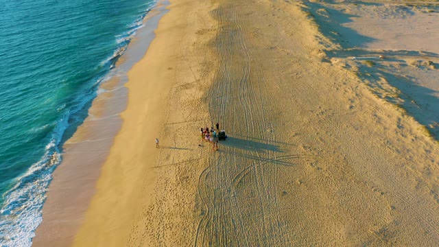 People and Dune Buggy Moving on Sandy Beach