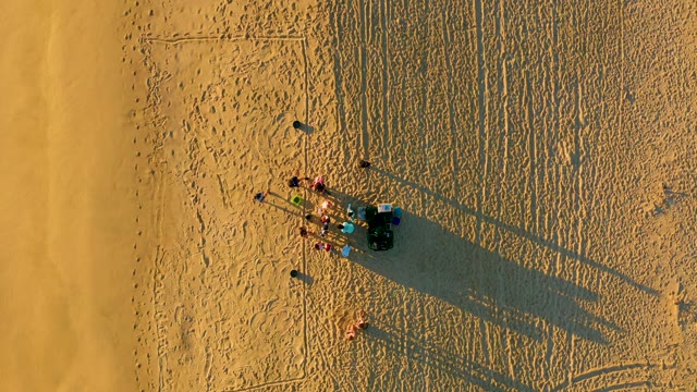 People Gathering Around a Dune Buggy on Sandy Dunes