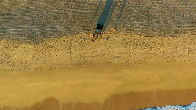 Beachgoers and Advancing Ocean Waves on Sandy Shore