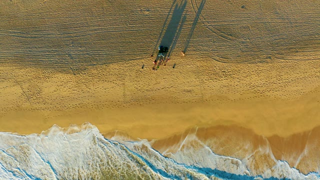 Receding Ocean Tide on Sandy Beach with People