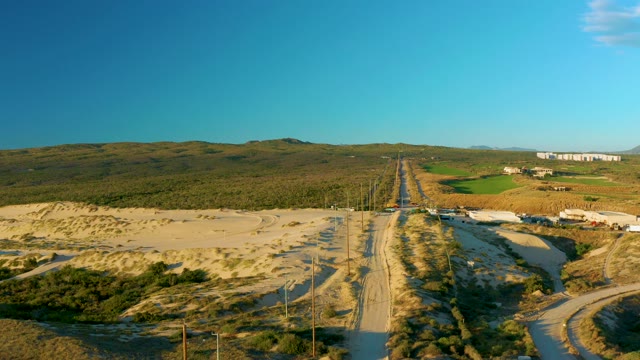 Road Winding Through Arid Hills with Sparse Vegetation