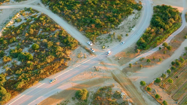 Vehicles Moving Through Rural Road Intersection