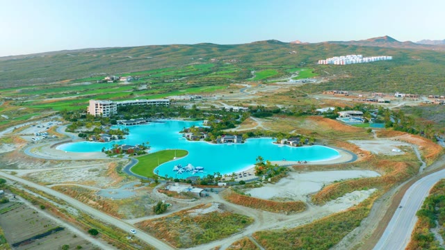 Curved Blue Pool and Hillside Roads in Arid Landscape