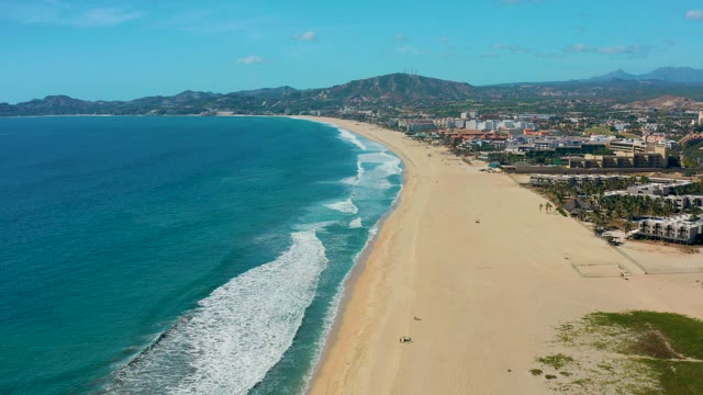 SAN JOSE DEL CABO BCS MEXICO-2020: Sandy Shore with Turquoise Ocean and Distant Buildings