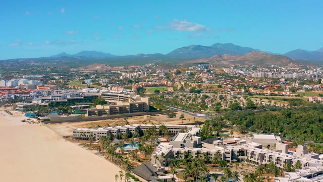 SAN JOSE DEL CABO BCS MEXICO-2020: Coastal Road with Vehicle Moving Past Beachfront Buildings
