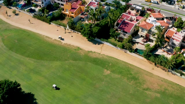 SAN JOSE DEL CABO BCS MEXICO-2020: Golf Cart Moving Along Course near Residential Buildings