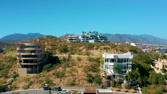 SAN JOSE DEL CABO BCS MEXICO-2020: Hillside Buildings with Moving Vehicles and Distant Mountains