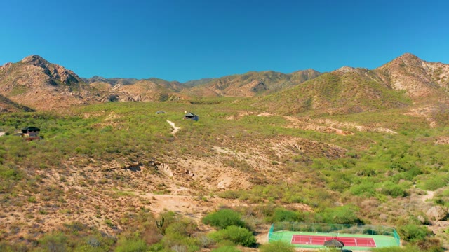 CABO PULMO BCS MEXICO-2020: Drone Moving Over Hilly Landscape with Distant Buildings