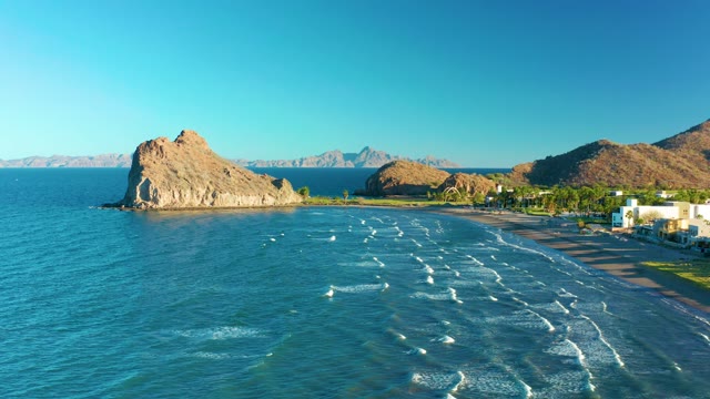 LORETO BCS MEXICO-2020: Ocean Waves Rolling Toward Sandy Beach and Rock Formation