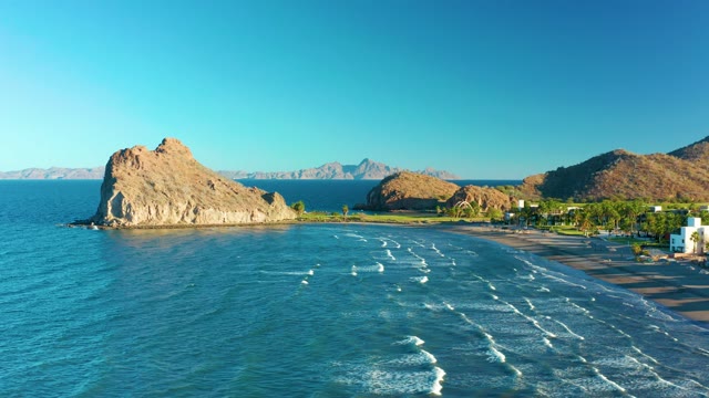 LORETO BCS MEXICO-2020: Gentle Ocean Waves Lapping Sandy Beach near Rocky Outcrop