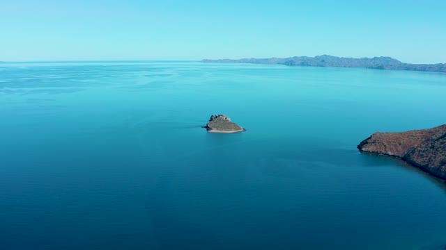 JUNCALITO BCS MEXICO-2020: Small Island with Bird Taking Off Over Calm Ocean