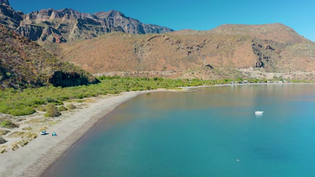 JUNCALITO BCS MEXICO-2020: Person and Boat Moving Along Sandy Coastal Shore