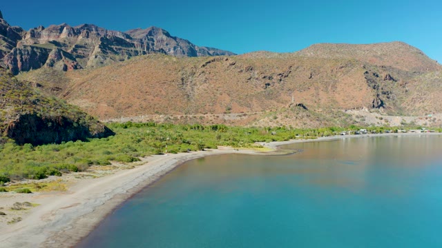 JUNCALITO BCS MEXICO-2020: Receding Waterline on Sandy Beach with Mountain Backdrop