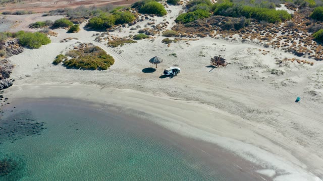 JUNCALITO BCS MEXICO-2020: White Van on Sandy Beach with Thatched Umbrella