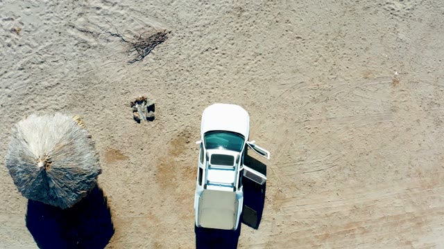 JUNCALITO BCS MEXICO-2020: White Car and Thatched Umbrella on Sandy Beach
