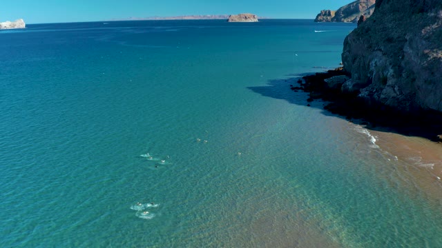 LIGUI BCS MEXICO-2020: People Swimming in Clear Ocean Near Rocky Shore