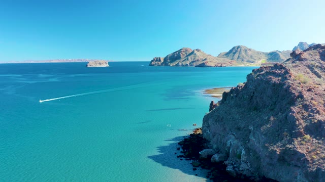 LIGUI BCS MEXICO-2020: Boat Moving Across Turquoise Waters Near Rocky Coast