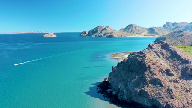 LIGUI BCS MEXICO-2020: Boat Moving Past Rocky Coastal Cliffs in Clear Water