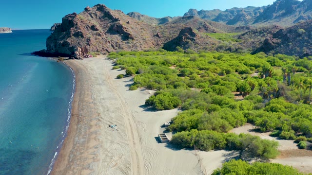 LIGUI BCS MEXICO-2020: Person Walking on Sandy Beach near Rocky Cliffs