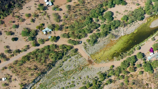SAN JAVIER BCS MEXICO-2020: Vehicles Moving Along Dirt Road near River in Dry Landscape