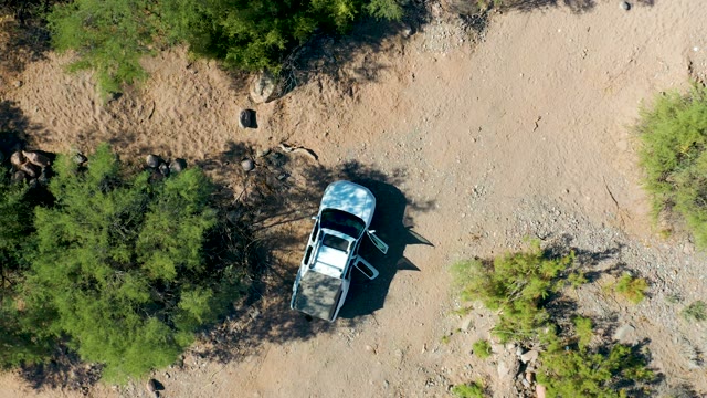 SAN JAVIER BCS MEXICO-2020: SUV Parked in Arid Rocky Landscape with Shifting Shadows