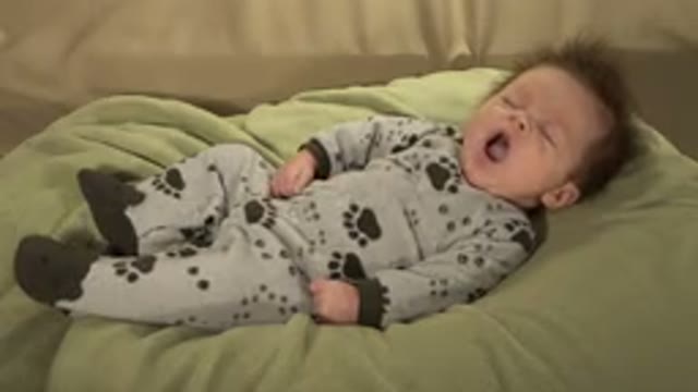 WESTMINSTER COLORADO-2015: Sleeping Baby Lying On Green Blanket Yawns And Opens Eyes