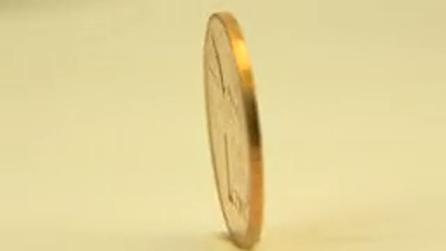 WESTMINSTER COLORADO-2015: A Circling Yellow Gold Coin on a Wooden Table Moving
