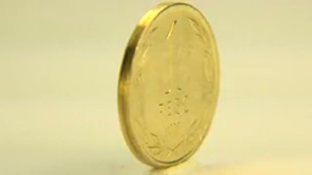 WESTMINSTER COLORADO-2015: A Gold Colored Coin Spinning Around On A Revolving Table