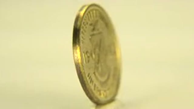WESTMINSTER COLORADO-2015: Spinning Golden Guinea Coin on Yellow Background