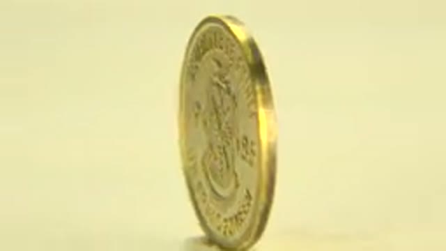 WESTMINSTER COLORADO-2015: Gold Coin Rotating in Yellowish Background