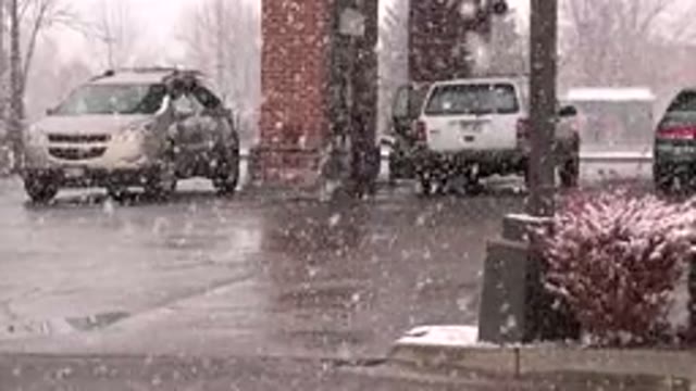 WESTMINSTER COLORADO-2015: Snow Falling on Cars at Gas Station on a Clear Day