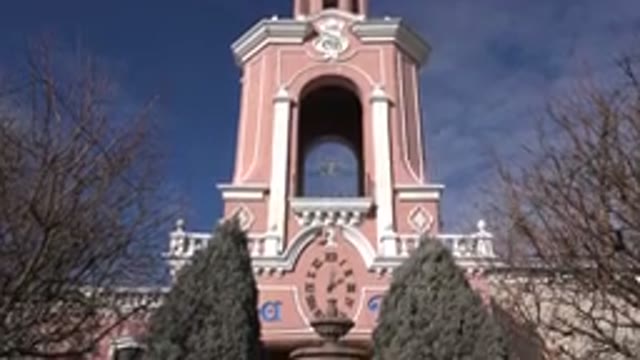 DENVER COLORADO-2015: Brown Bird Bath In Front Of Pink And White Clock Tower On