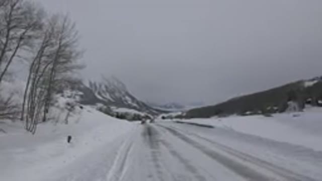 CRESTED BUTTE COLORADO-2015: Two Motor Vehicles Driving Around A Curve In The