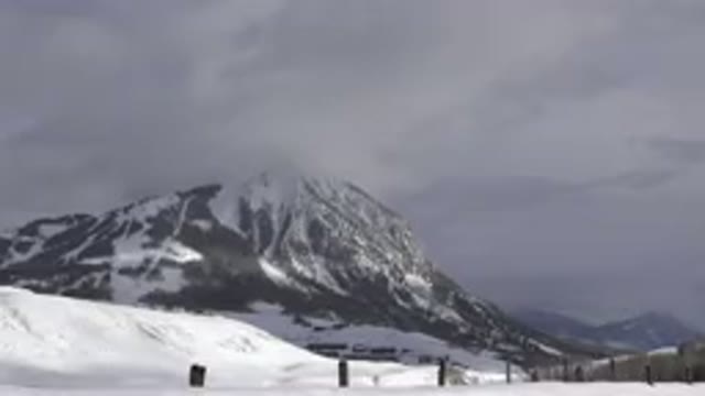 CRESTED BUTTE COLORADO-2015: A Snow-Dusted Mountain Rising Through Clouds