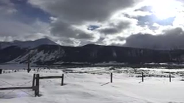 CRESTED BUTTE COLORADO-2015: A Car Drives In Front Of A Snow Covered Mountain
