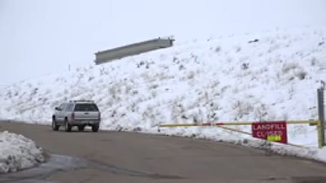 ARVADA COLORADO-2015: Panning Shot Of A SUV Parked On A Road To A Closed Landfill