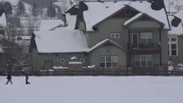 ARVADA COLORADO-2015: People Walking By On A Snowy Day With A House Covered In